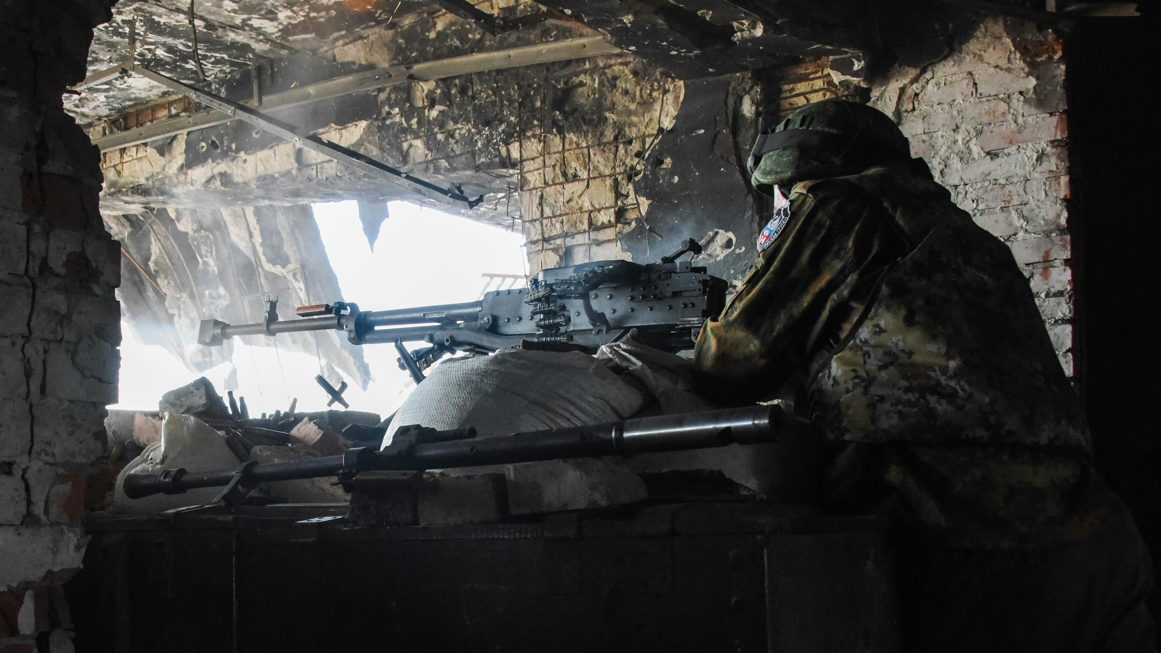 Ein Soldat schießt aus der Deckung eines zerstörten Hauses.