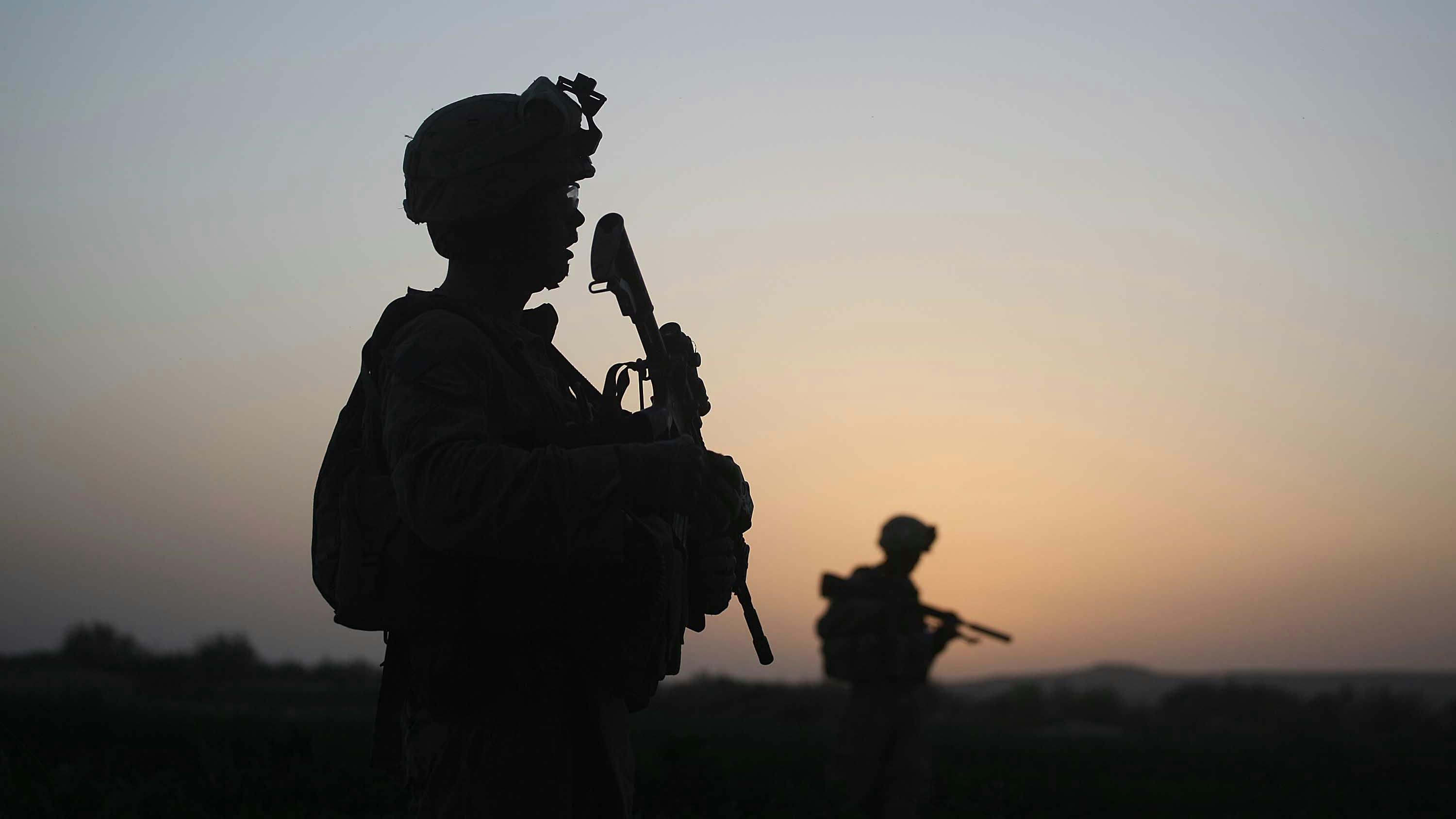 Wir sehen zwei Soldaten im Gegenlicht, im Hintergrund afghanische Landschaft in der Abendsonne.