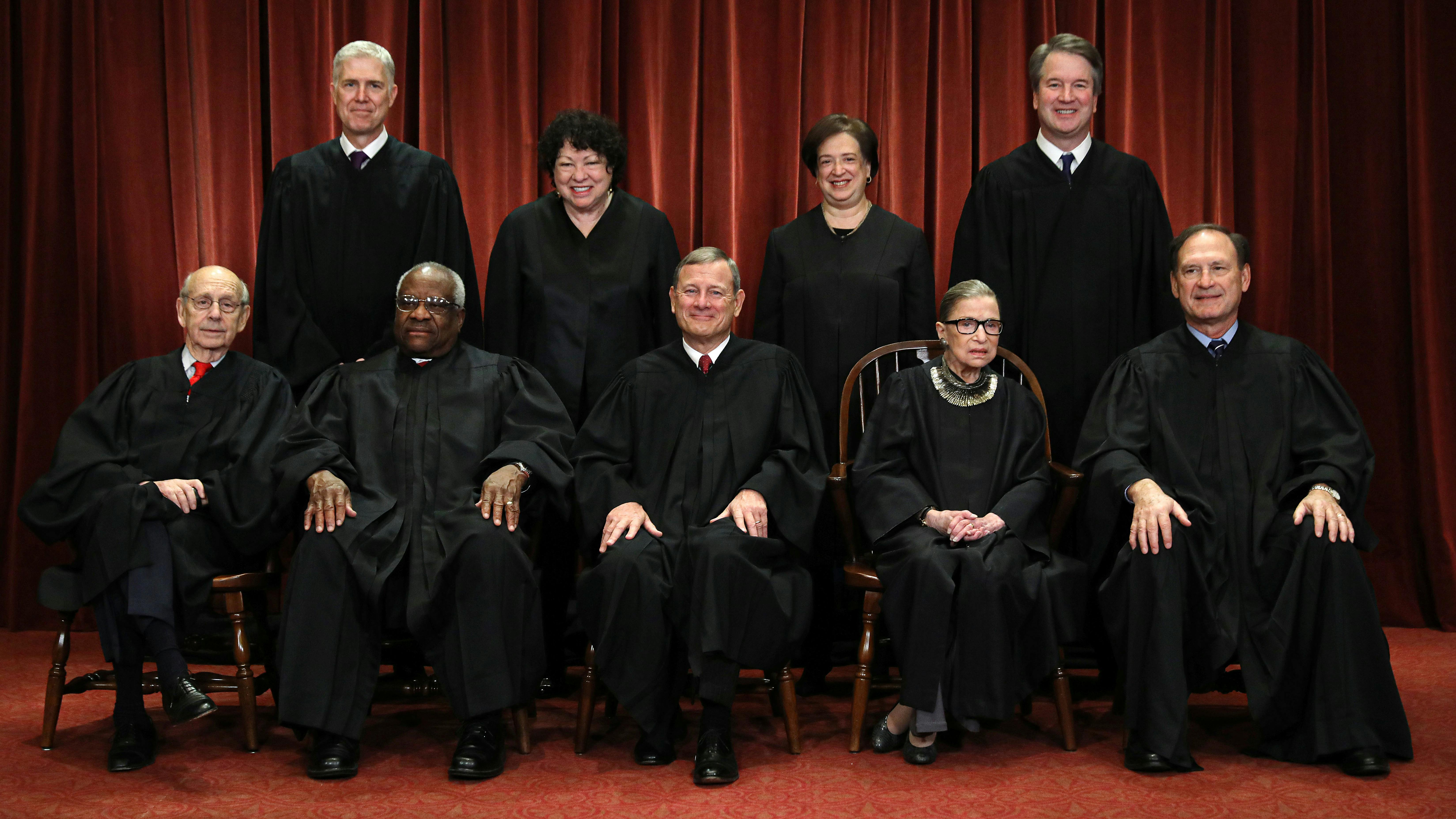 Wir sehen auf diesem Foto die neun Richter des Supreme Court in ihren Roben, es ist ein Bild von 2018, deshalb sind auch Ruth Bader Ginsburg und Brett Kavanaugh zu sehen. 