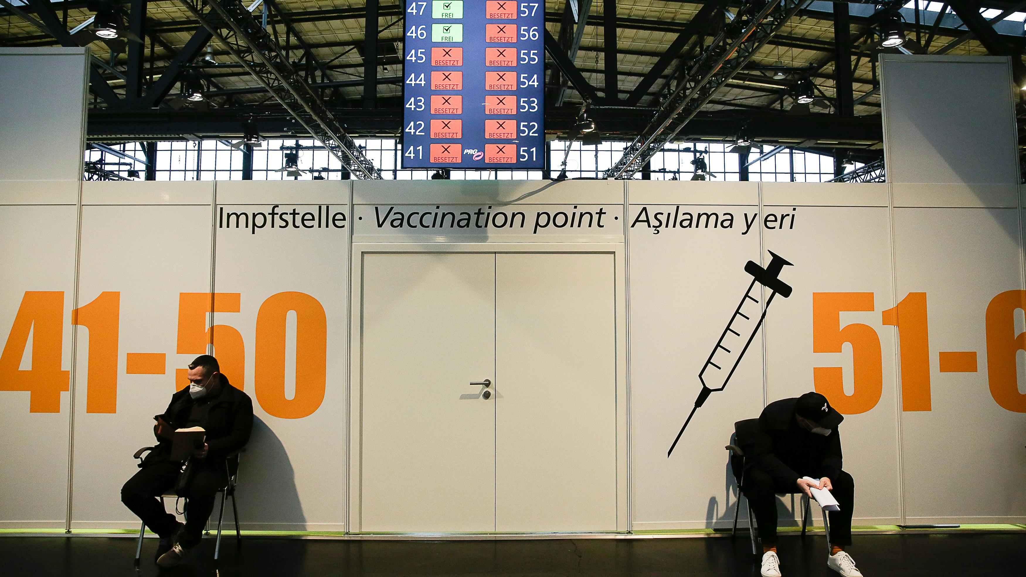 Zwei Männer warten auf ihre Impfung gegen das Coronavirus und die Krankheit Covid-19 im Impfzentrum Arena Treptow am 27. Dezember 2020 in Berlin, Deutschland. 