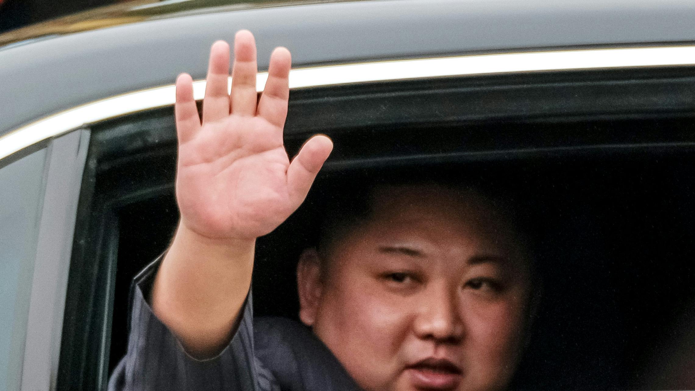 Kim Jong Il winkt aus einer schwarzen Limusione. 