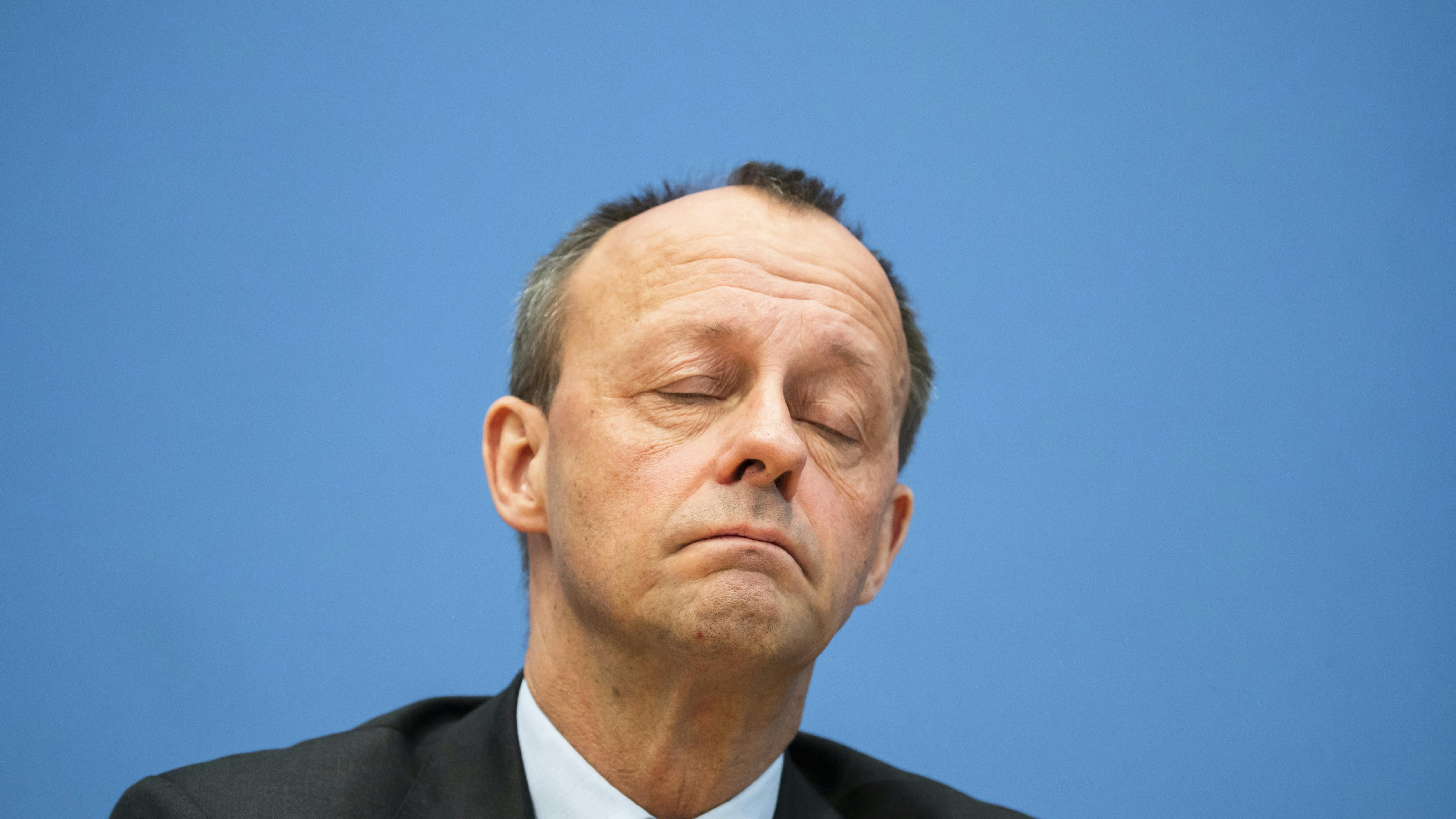 Portrait von Friedrich Merz. Seine Augen sind geschlossen.