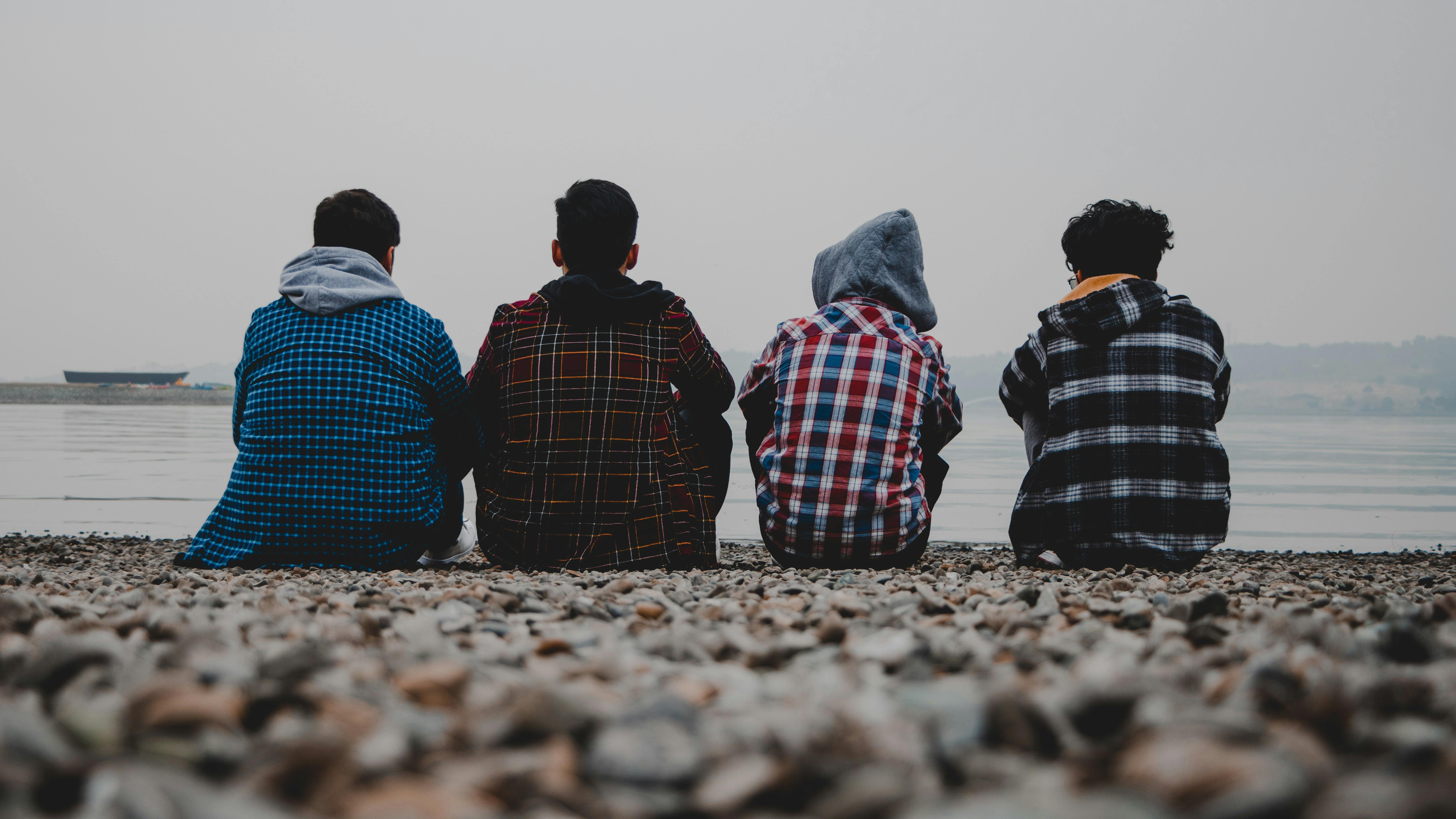 Eine Gruppe Jugendlicher sitzt an einer Küste.