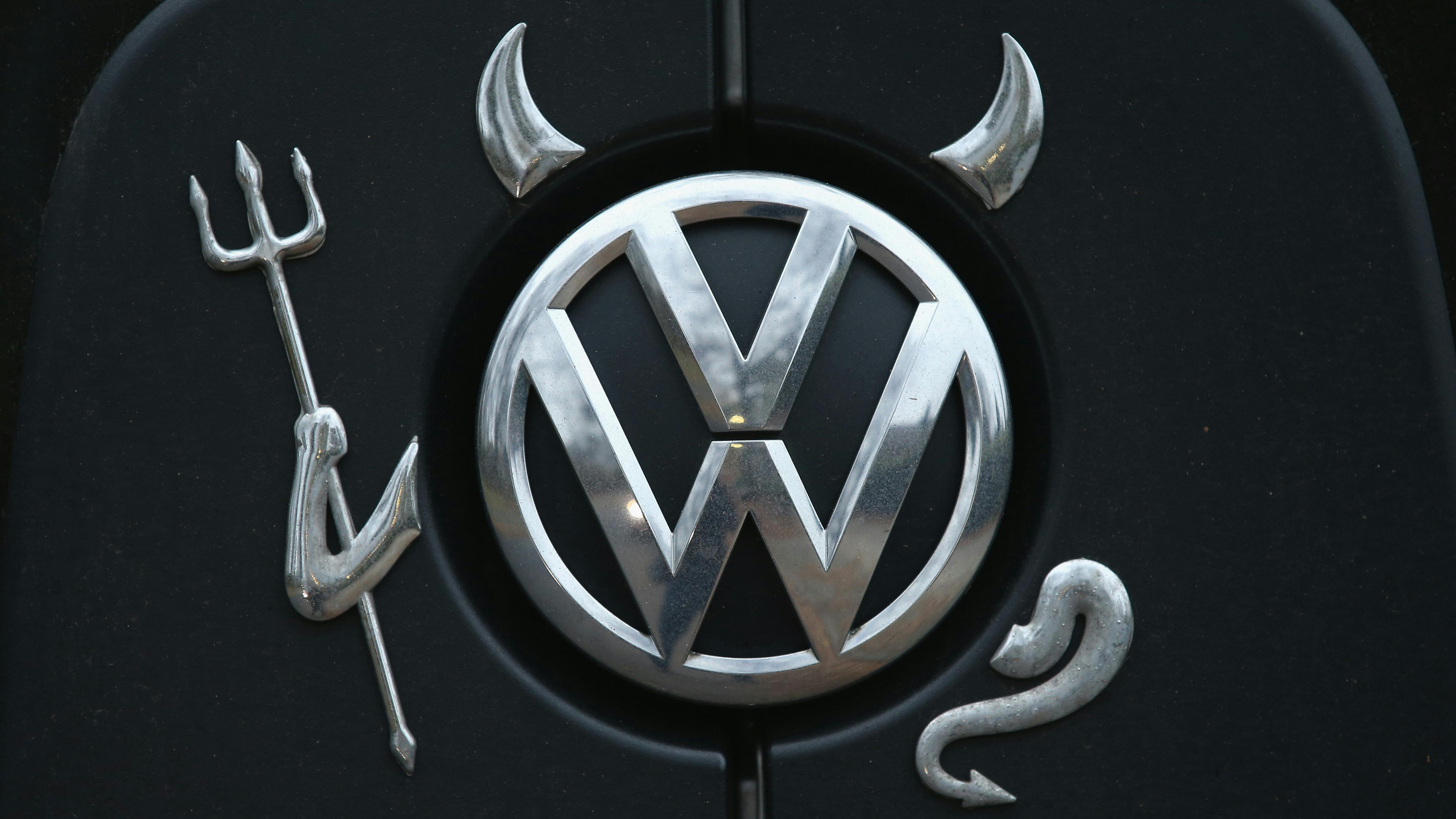 Ein Volkswagen-Logo mit Hörnern, einer Mistgabel und einem Schwanz in Gestalt eines Teufels ziert einen VW-Bus.