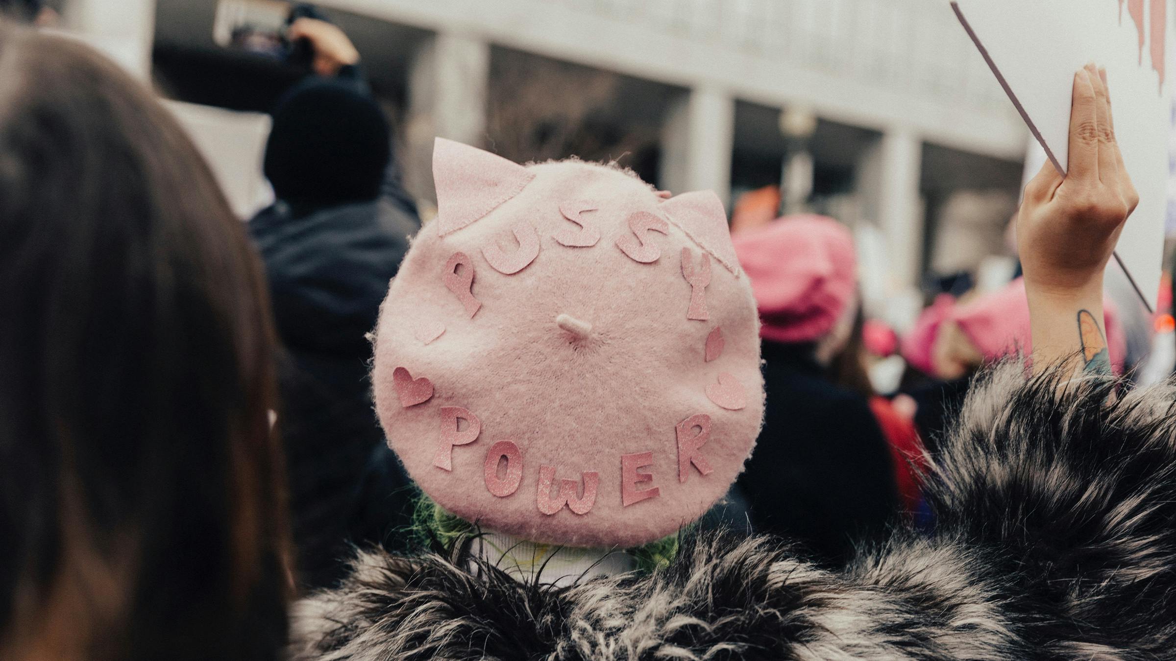 Frau mit rosa Mütze und der Aufschrift „Pussy Power“ demonstriert