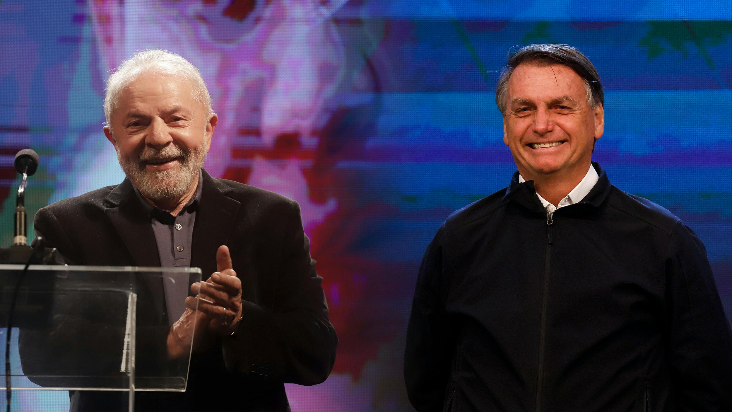 Fotomontage: Lula da Silva steht auf einer Bühne und klatscht. Er trägt ein schwarzes Sakko und ein dunkelgraues Hemd. Neben ihm steht Bolsonaro. Er trägt einen schwarzen Pullover und ein weißes Hemd.