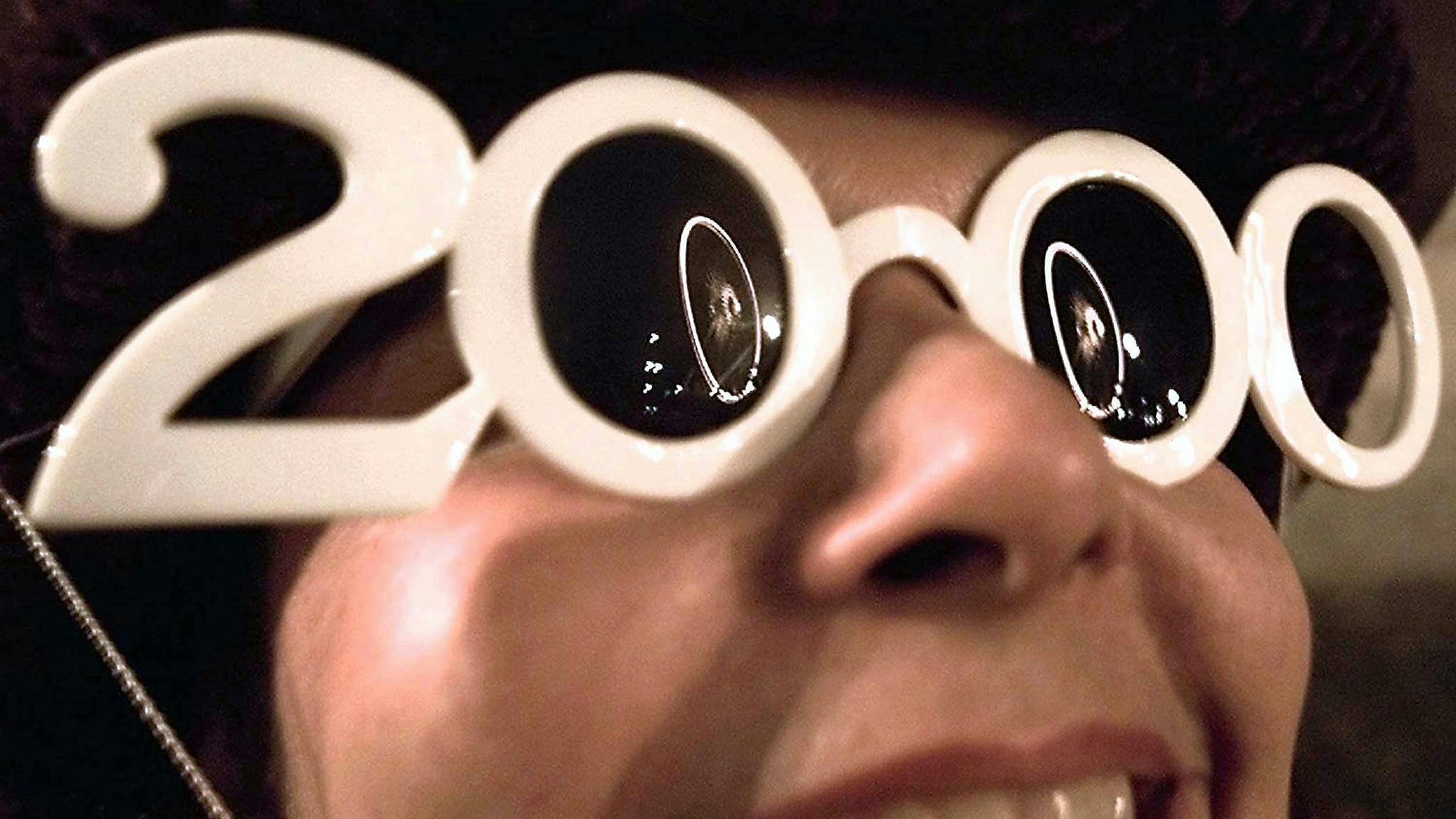 Eine Frau trägt eine 2000-er Silvesterbrille
