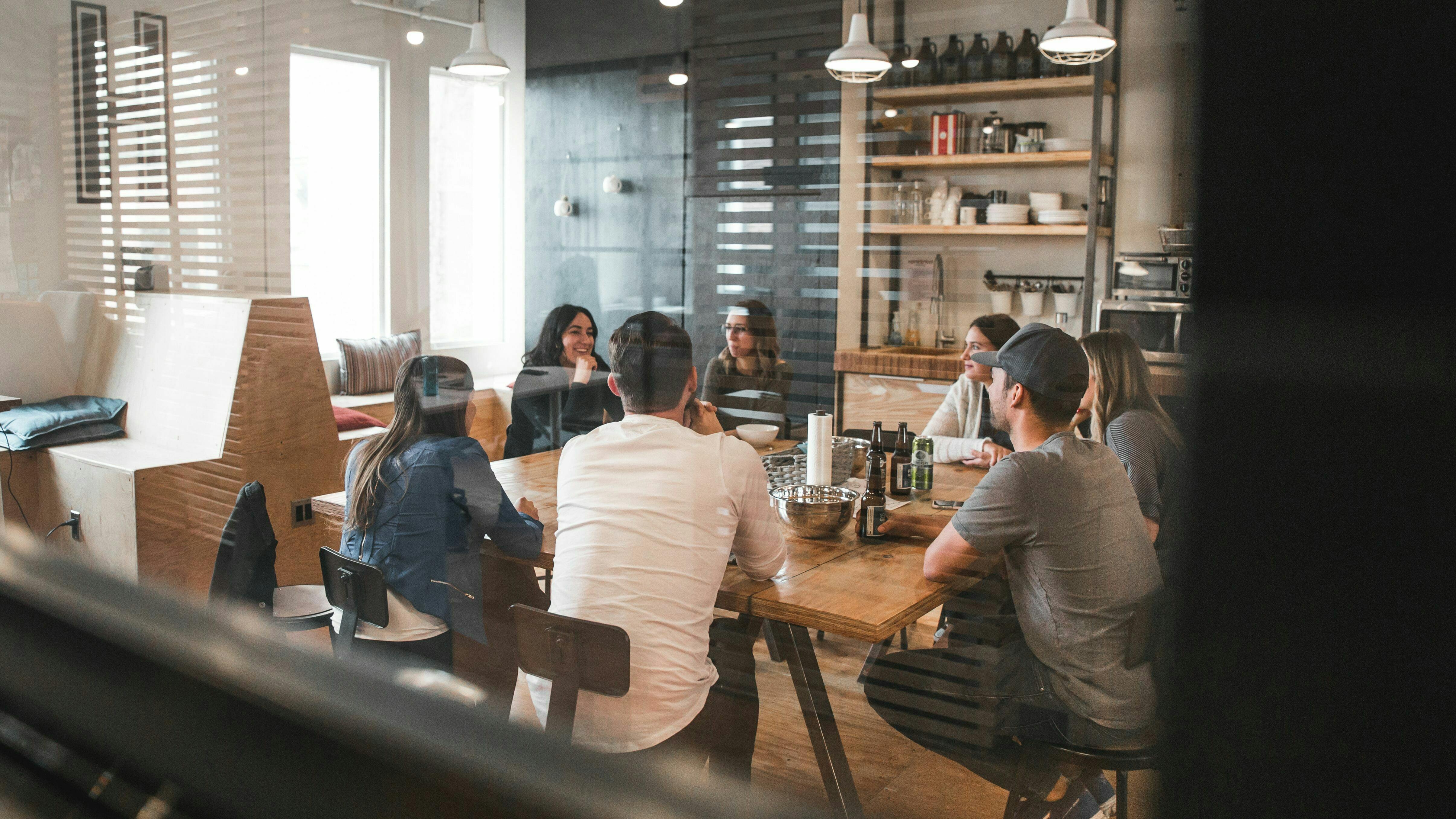 Menschen sitzen um einen Tisch und unterhalten sich