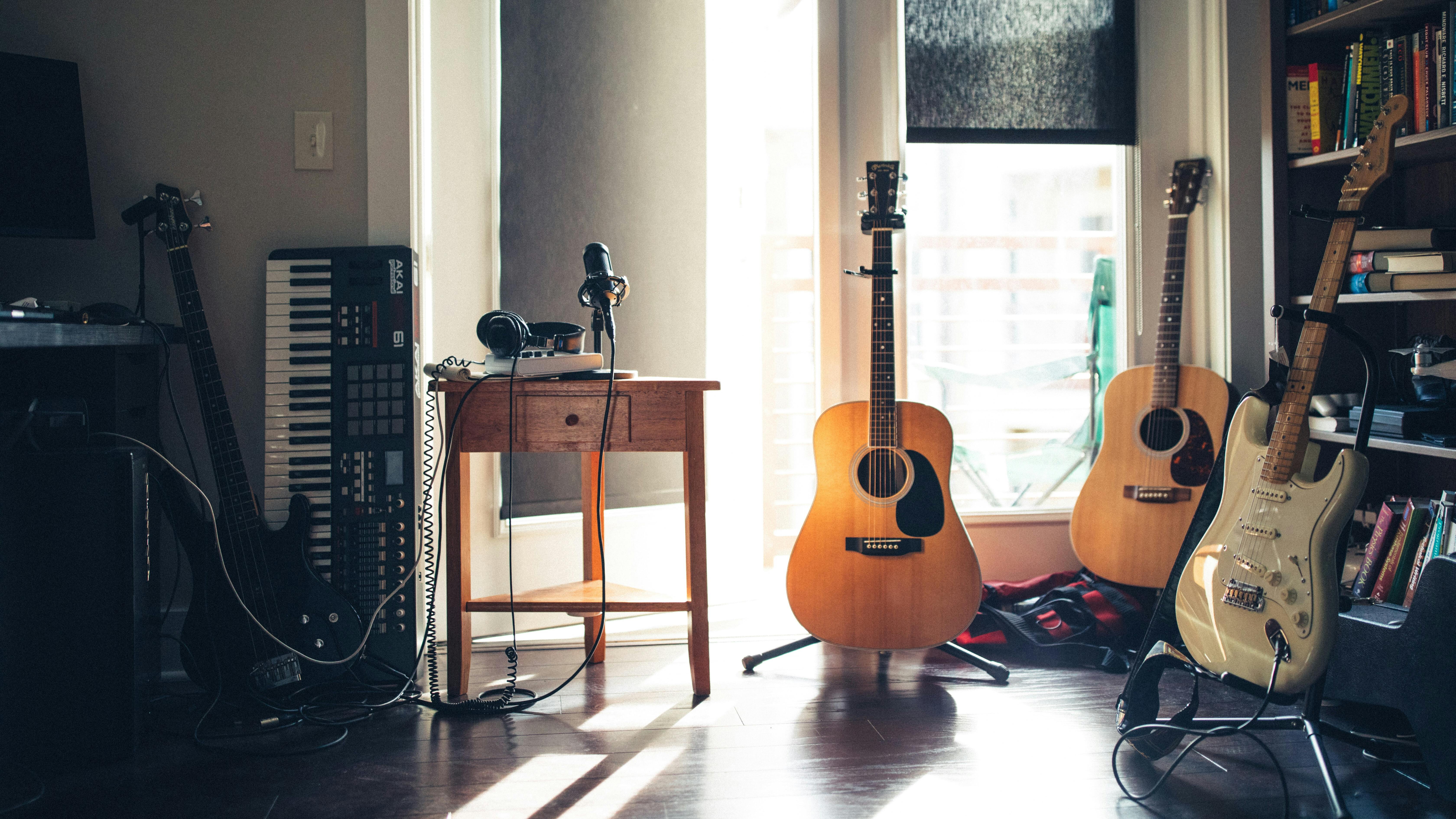 Ein heller Raum mit Instrumenten: zwei akustische Gitarren, zwei E-Gitarren und ein Keyboard