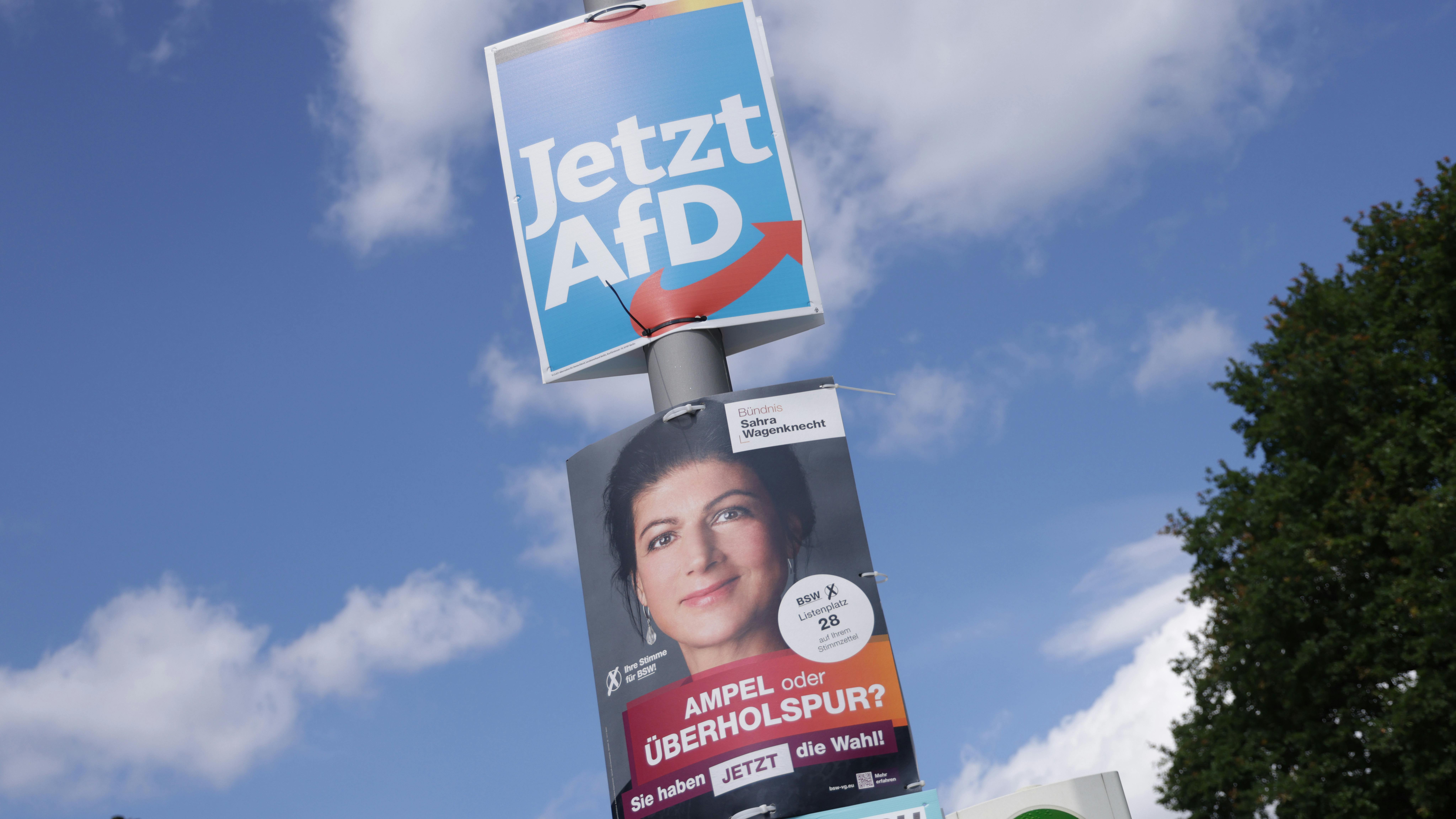 Ein Wahlplakat der AfD hängt über einem Wahlplakat des BSW. 