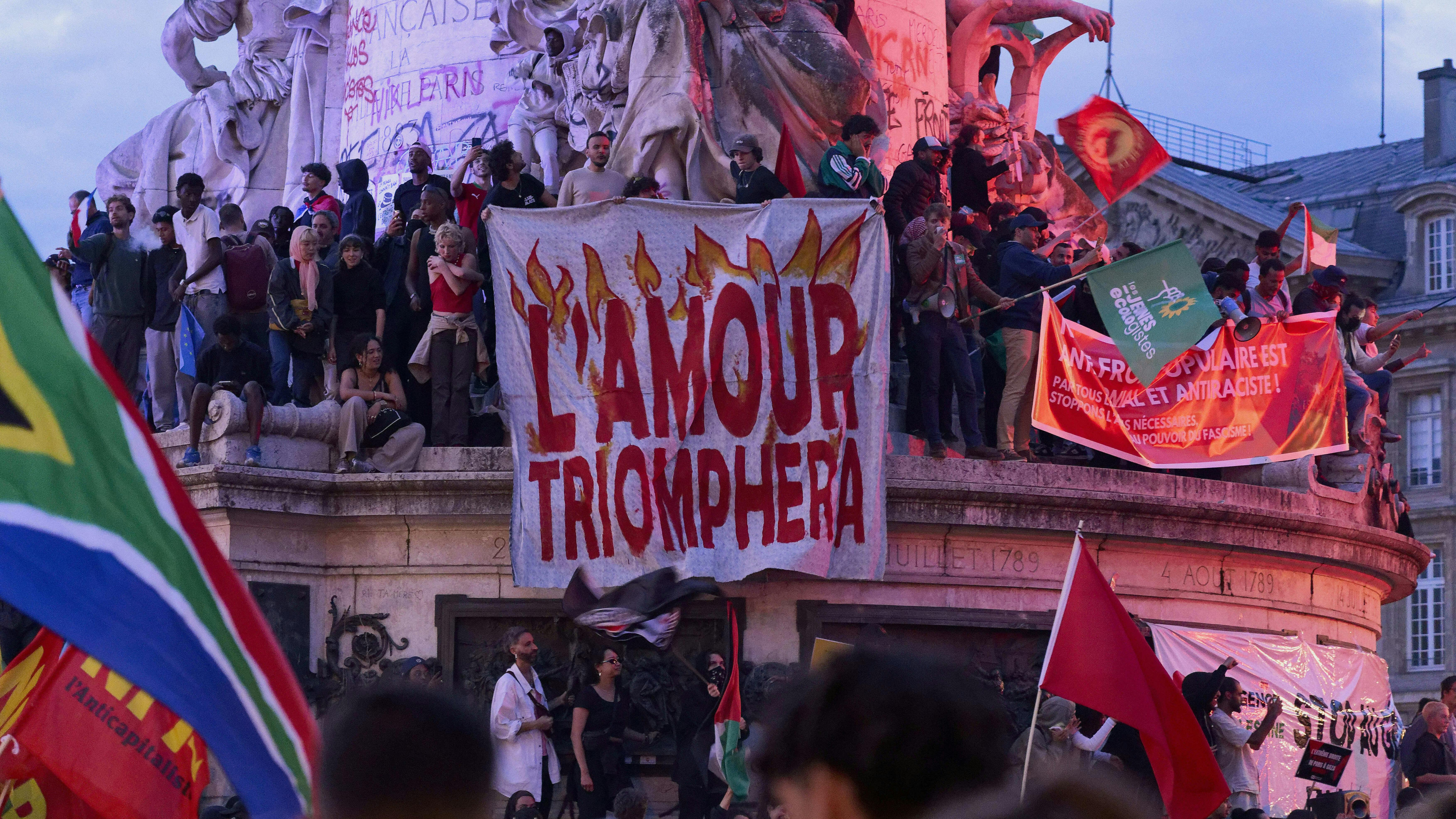 Französische Demonstrierende halten ein Schild mit der Aufschrift „Die Liebe wird siegen“.