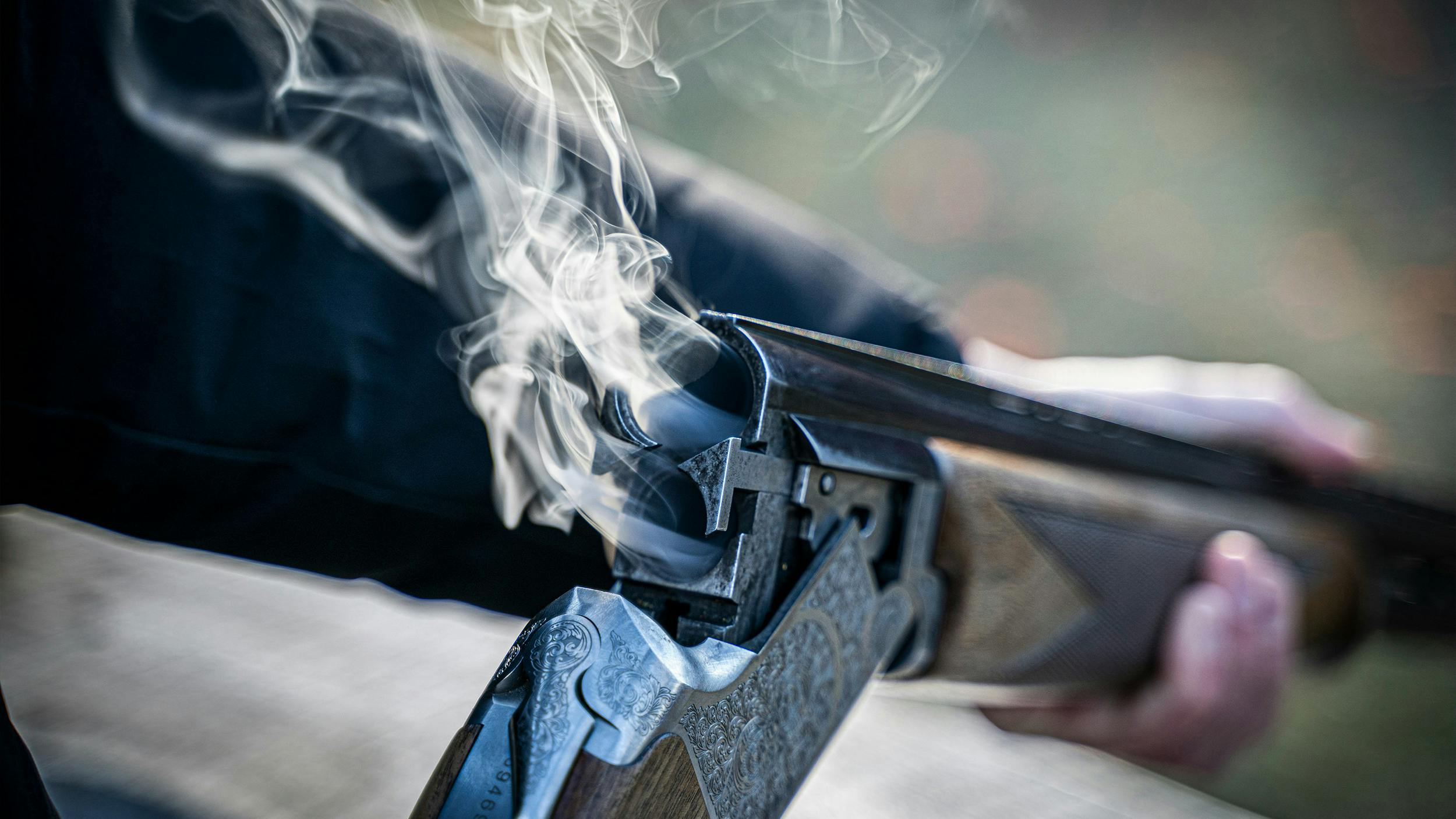 Eine doppelläufige Waffe bei der der Lauf aufgeklappt ist. Rauch kommt aus den Rohren.