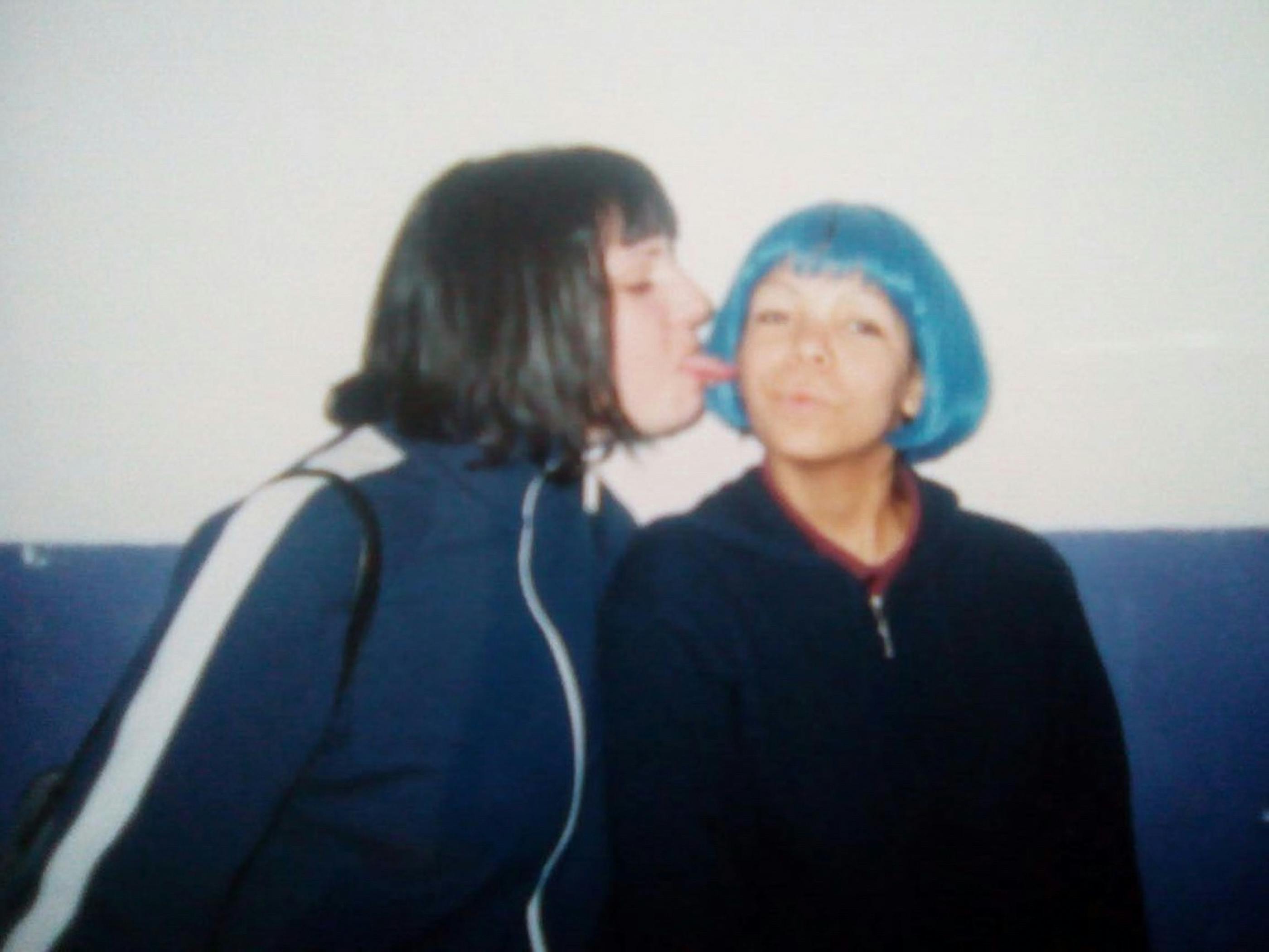 Wir sehen die Autorin im Alter von ca. 13 Jahren mit blauen Haaren – ein zweites Mädchen streckt neben ihr der Autorin Zunge raus, es ist dennoch ein freundschaftliches Bild.